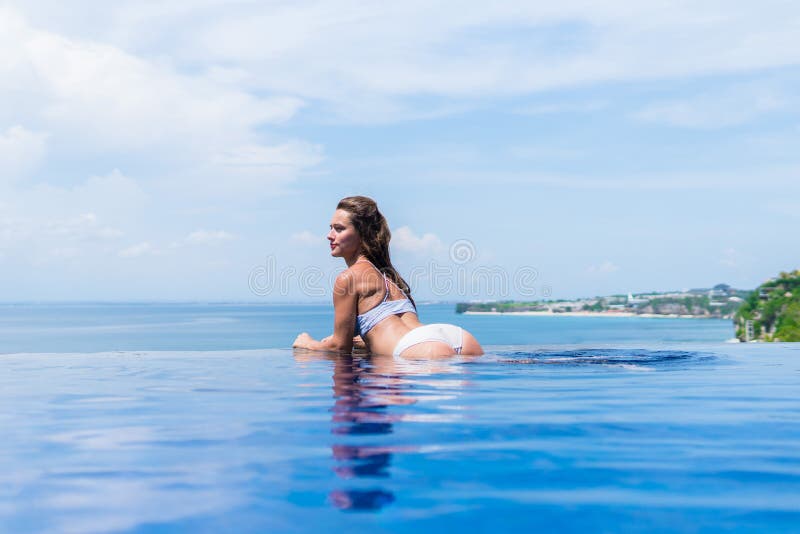 Sexy meisje Mooie vrouw de model van de het ondergoed grote ezel van de damebikini het uiteindebuit zit rand van water zwemt pool stock fotografie Sexy meisje Mooie vrouw de model van de het ondergoed grote ezel van de damebikini het uiteindebuit zit rand van water zwemt pool stock fotografie