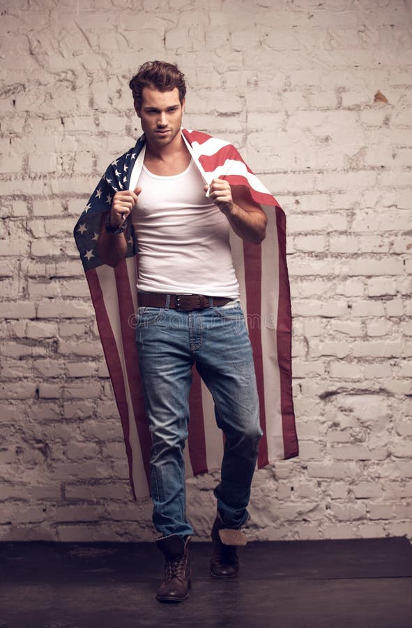 Sexy mens die Amerikaanse vlag zoals een mantel gebruiken. stock foto's Sexy mens die Amerikaanse vlag zoals een mantel gebruiken. stock foto's