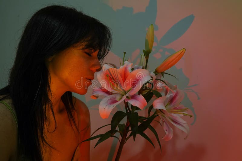Sexy Model Girl mit Modebukett von schönen Blumen in bunten Modelichtern. Partei. Schönheitsjunge Frau mit stockfoto