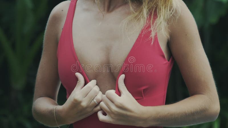 Sexy Modell der Zeitlupenahaufnahme im roten Badeanzug berührt ihr Haar