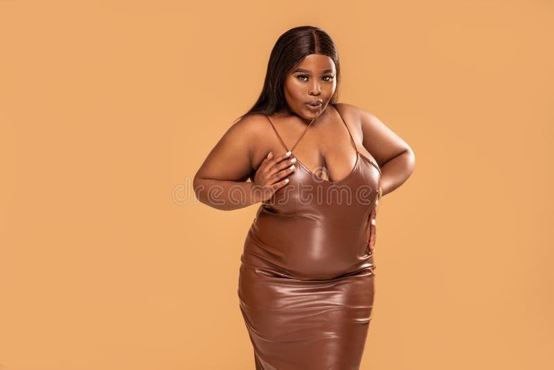 Plus Size African Woman Posing in Brown Leather Dress, Looking at