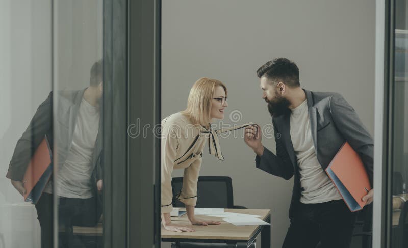 secretary seduce boss in office. Businesswoman on desktop look at bearded businessman. Man under woman domination stock images secretary seduce boss in office. Businesswoman on desktop look at bearded businessman. Man under woman domination stock images