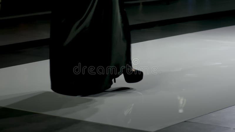 Girl heels sexy step foot closeup on defile catwalk in light spotlight scene 4K.