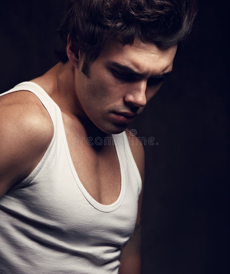strong sad handsome man posing in white t-shirt and looking