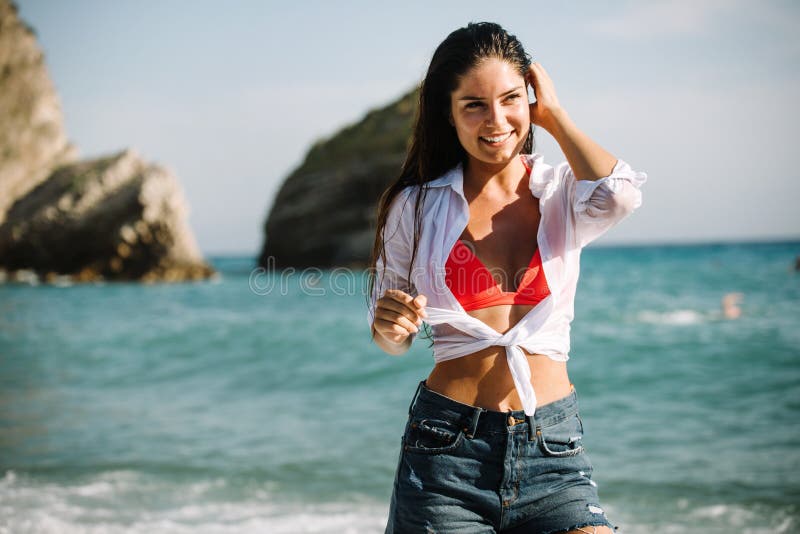 Sexy woman on beach posing in wet bikini