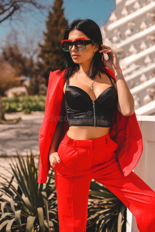 Fashion Outdoor Photo Of Beautiful Sexy Woman With Dark Hair In Elegant Red  Suit With Accessories Walking By The Street Stock Photo, Picture and  Royalty Free Image. Image 119892401.