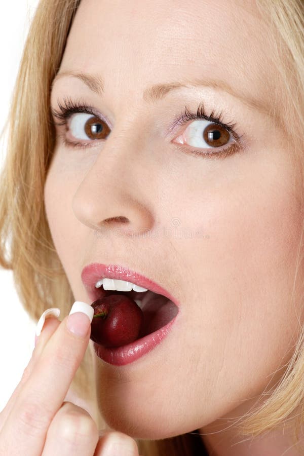 Woman eating a cherry. Close up woman eating a cherry Woman eating a cherry. Close up woman eating a cherry