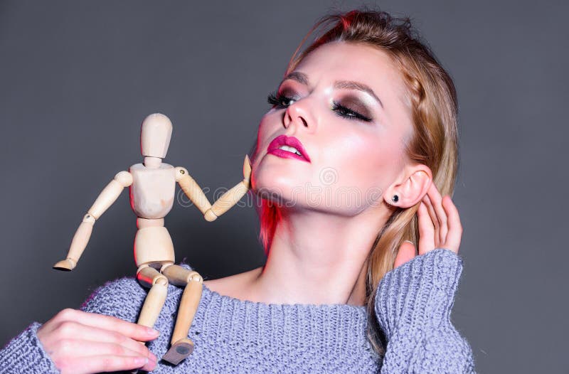 sexy woman with fashion makeup. wooden figure on shoulder of girl. natural beauty. artificial fashion. vogue concept stock photography