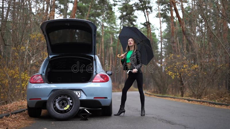 Sexy woman on the heels with broken car hitchhiking. Concept of sexuality and fetish