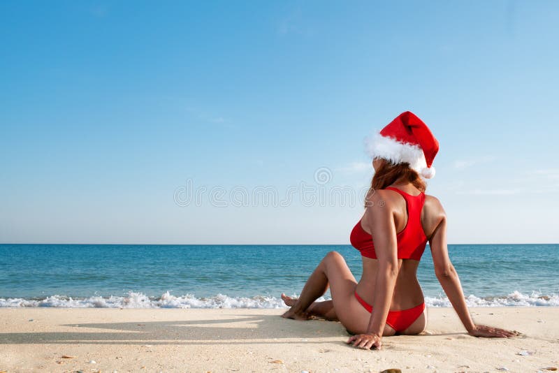 woman in santa hat on sea