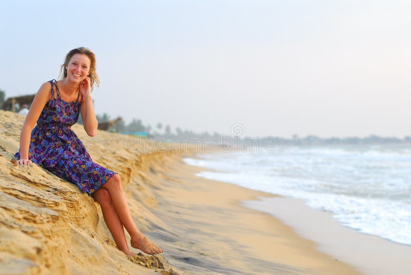 young blond girl sitting on beach