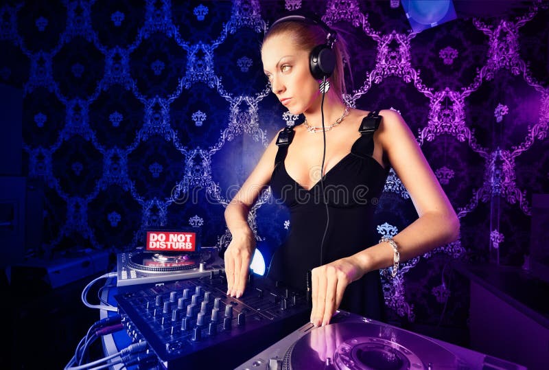Young blonde lady DJ playing music. 