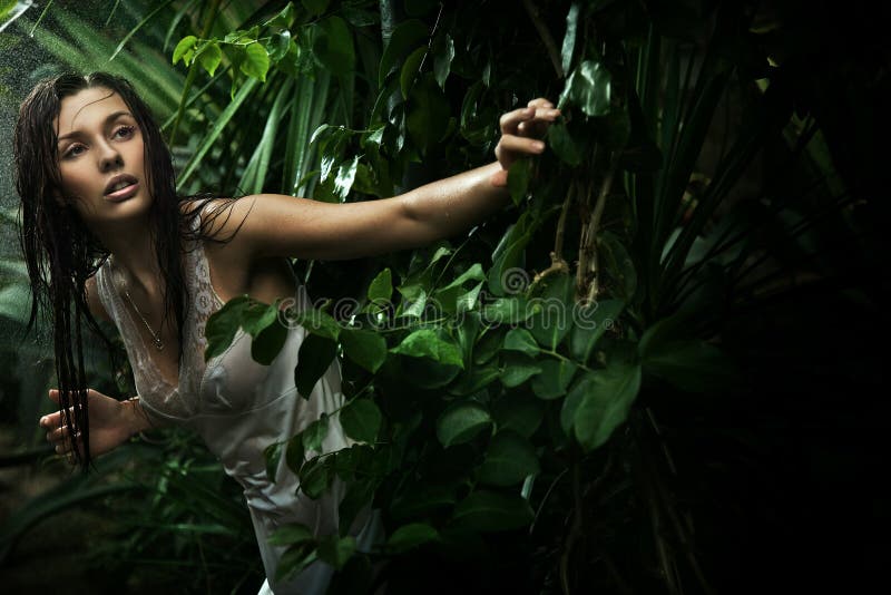Giovane ragazza nella meravigliosa foresta durante la pioggia.