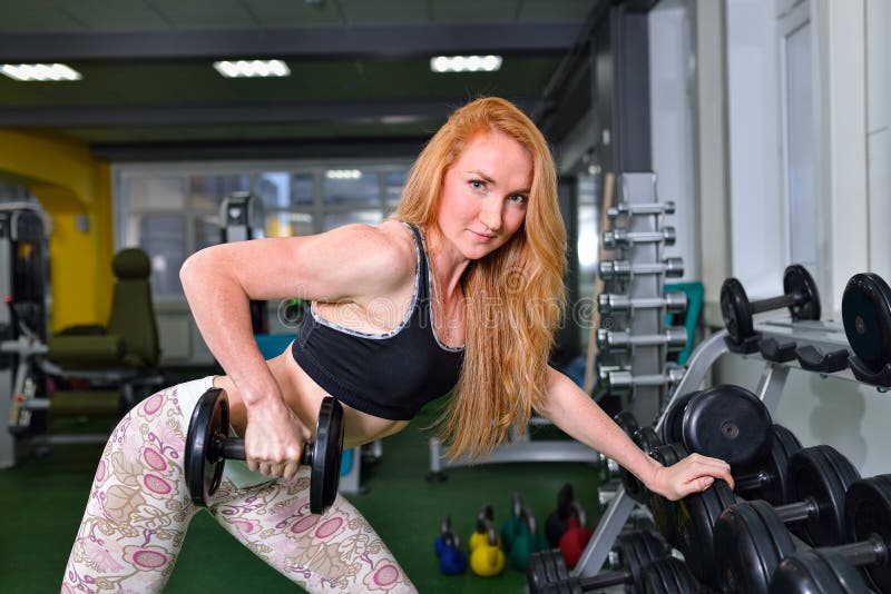young girl exercises with dumbbells. Fitness woman workout in gym stock photos young girl exercises with dumbbells. Fitness woman workout in gym stock photos
