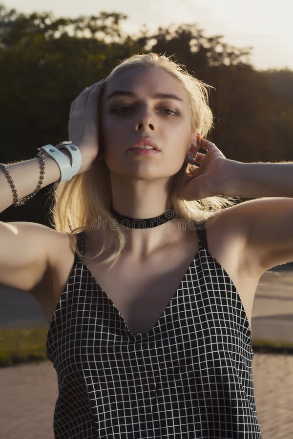 young model with chocker on her neck posing at the park in