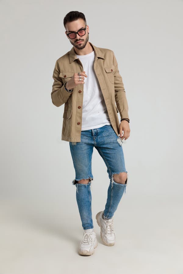 Young Unshaved Model in Jacket Holding Hands and Walking Stock Image ...