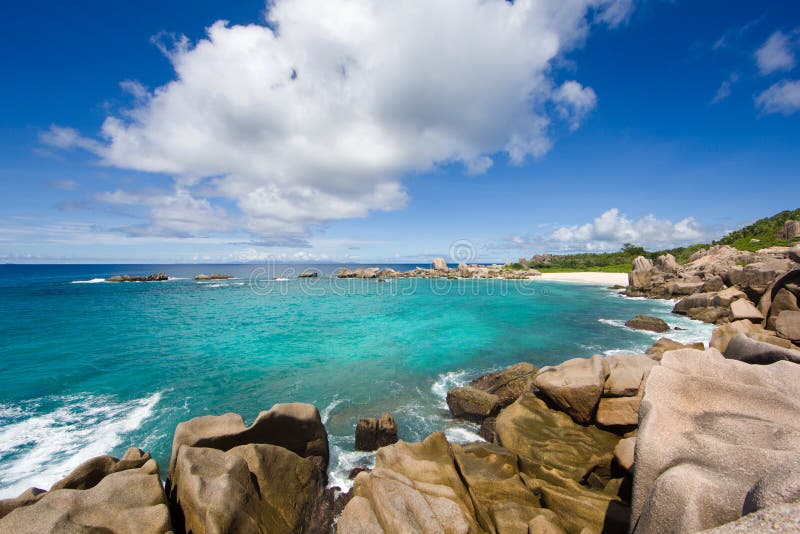 Seychelles island landscape, rocks, turquise sea, clouds, blue sky.