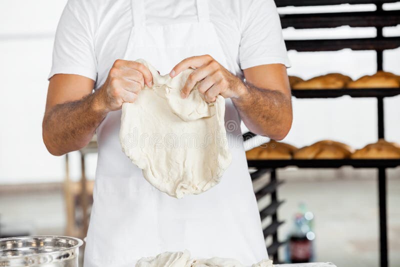 Seção mestra da padaria de Holding Dough In do padeiro fotos de stock Seção mestra da padaria de Holding Dough In do padeiro fotos de stock