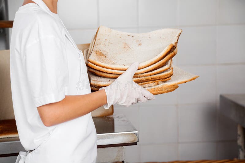 Seção mestra do padeiro Holding Bread Waste na padaria imagem de stock Seção mestra do padeiro Holding Bread Waste na padaria imagem de stock