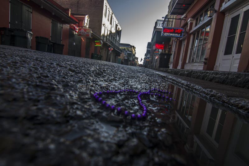 Bourbon street early morning neon signs in New Orleans streets with water from washing. Bourbon street early morning neon signs in New Orleans streets with water from washing