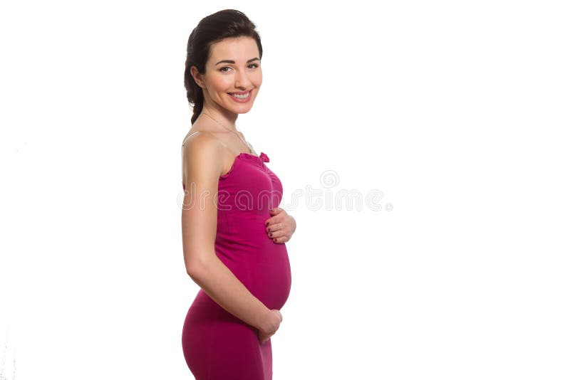 Señora embarazada sonriente del caucásico joven en belio conmovedor del vestido rosado foto de archivo Señora embarazada sonriente del caucásico joven en belio conmovedor del vestido rosado foto de archivo