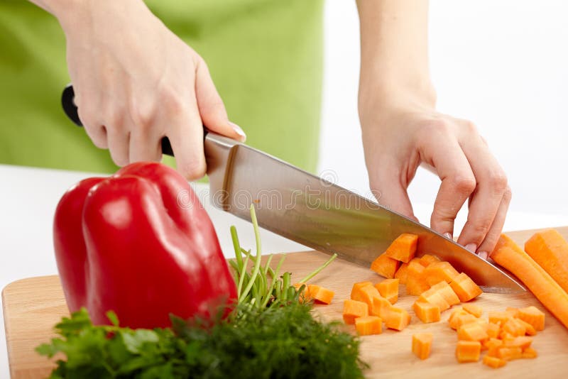 Señora joven que taja verduras imagen de archivo libre de regalías Señora joven que taja verduras imagen de archivo libre de regalías