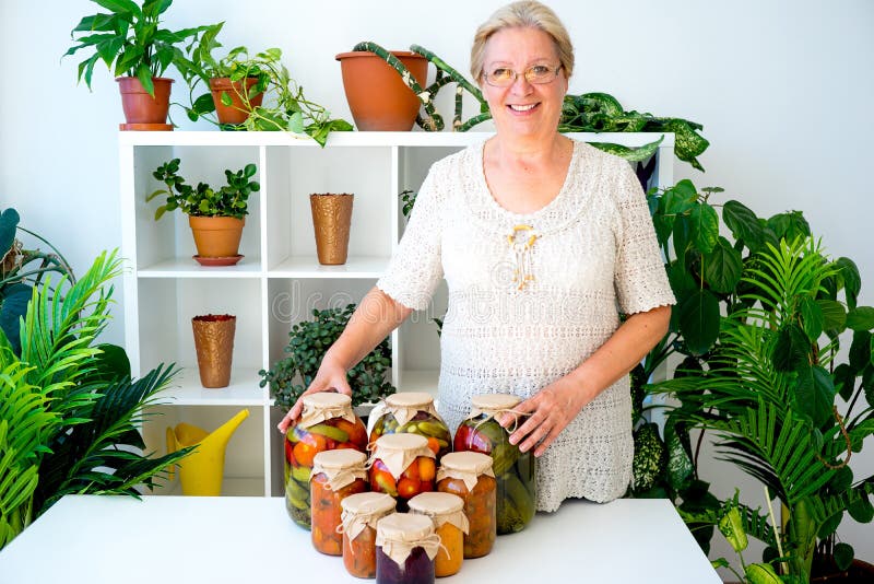Señora mayor con la comida conservada en vinagre fotografía de archivo