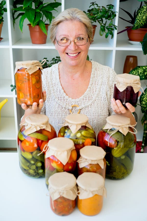 Señora mayor con la comida conservada en vinagre imagen de archivo libre de regalías