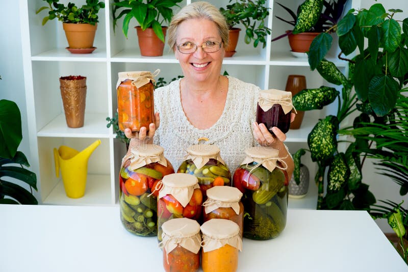 Señora mayor con la comida conservada en vinagre foto de archivo