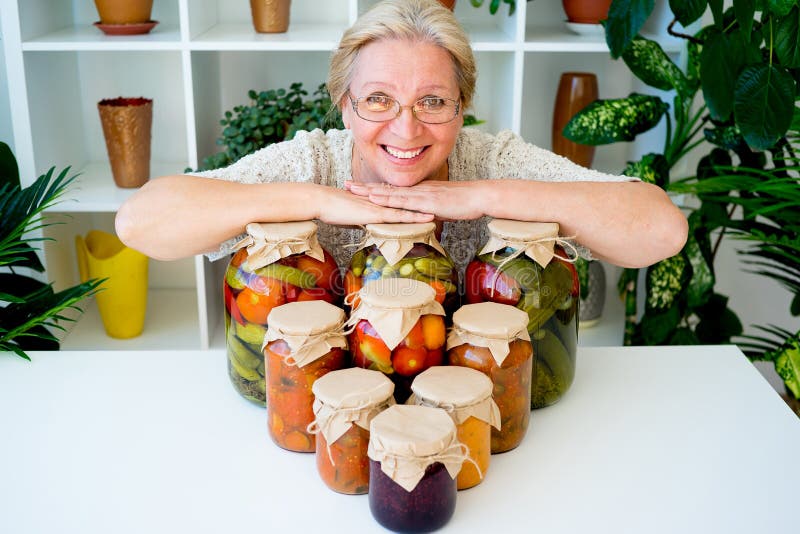 Señora mayor con la comida conservada en vinagre fotos de archivo