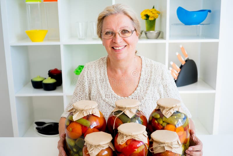 Señora mayor con la comida conservada en vinagre foto de archivo libre de regalías