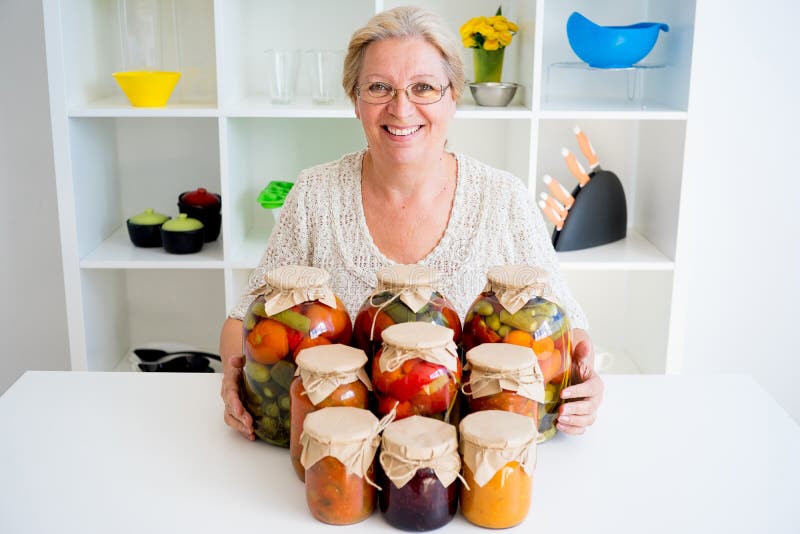 Señora mayor con la comida conservada en vinagre fotografía de archivo