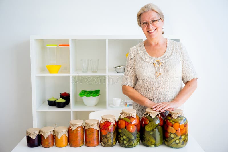 Señora mayor con la comida conservada en vinagre fotos de archivo