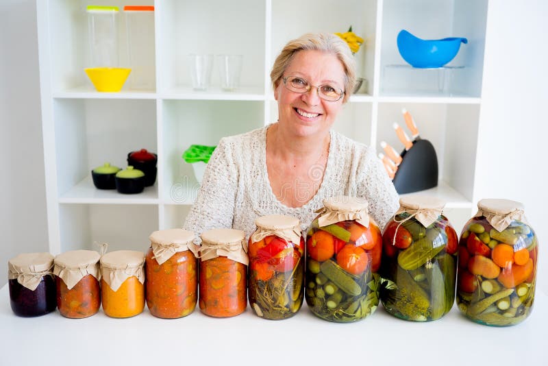 Señora mayor con la comida conservada en vinagre fotografía de archivo libre de regalías