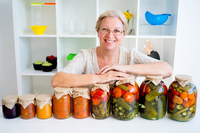 Señora mayor con la comida conservada en vinagre fotos de archivo libres de regalías