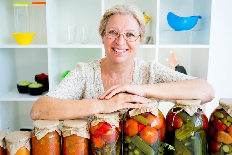 Señora mayor con la comida conservada en vinagre imagenes de archivo