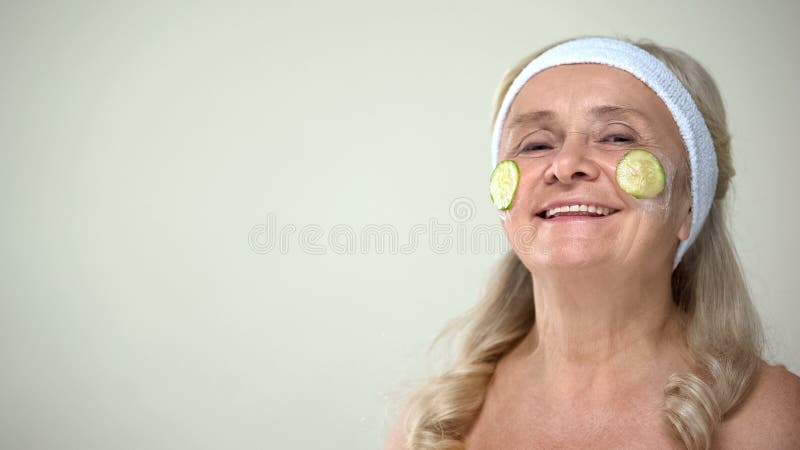 Señora mayor positiva que aplica la mascarilla del pepino, actitud optimista para envejecer imágenes de archivo libres de regalías Señora mayor positiva que aplica la mascarilla del pepino, actitud optimista para envejecer imágenes de archivo libres de regalías