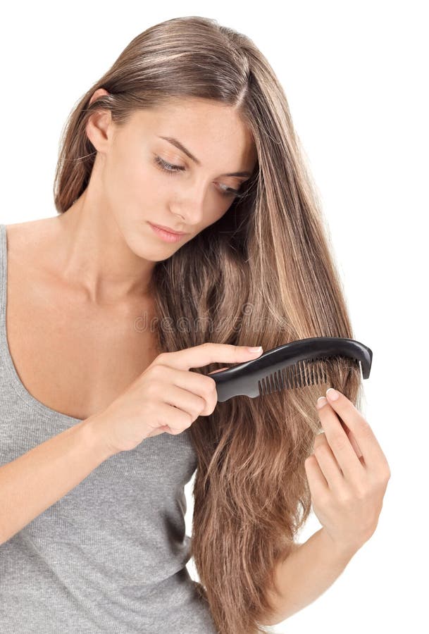 Young brunette beautiful lady combing long hairs on white. Young brunette beautiful lady combing long hairs on white