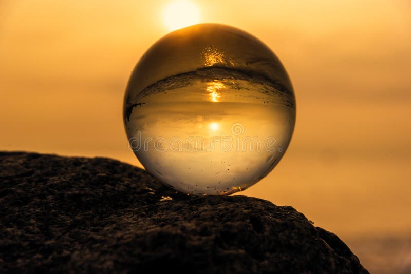 Sfera di cristallo sulla spiaggia con le onde del mare ad alba di mattina thailand fotografia stock libera da diritti Sfera di cristallo sulla spiaggia con le onde del mare ad alba di mattina thailand fotografia stock libera da diritti