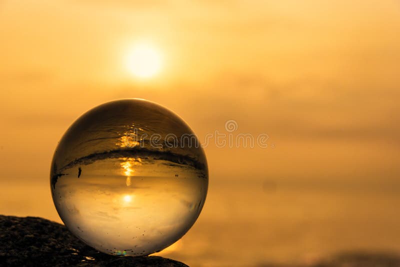Sfera di cristallo sulla spiaggia con le onde del mare ad alba di mattina thailand fotografia stock Sfera di cristallo sulla spiaggia con le onde del mare ad alba di mattina thailand fotografia stock