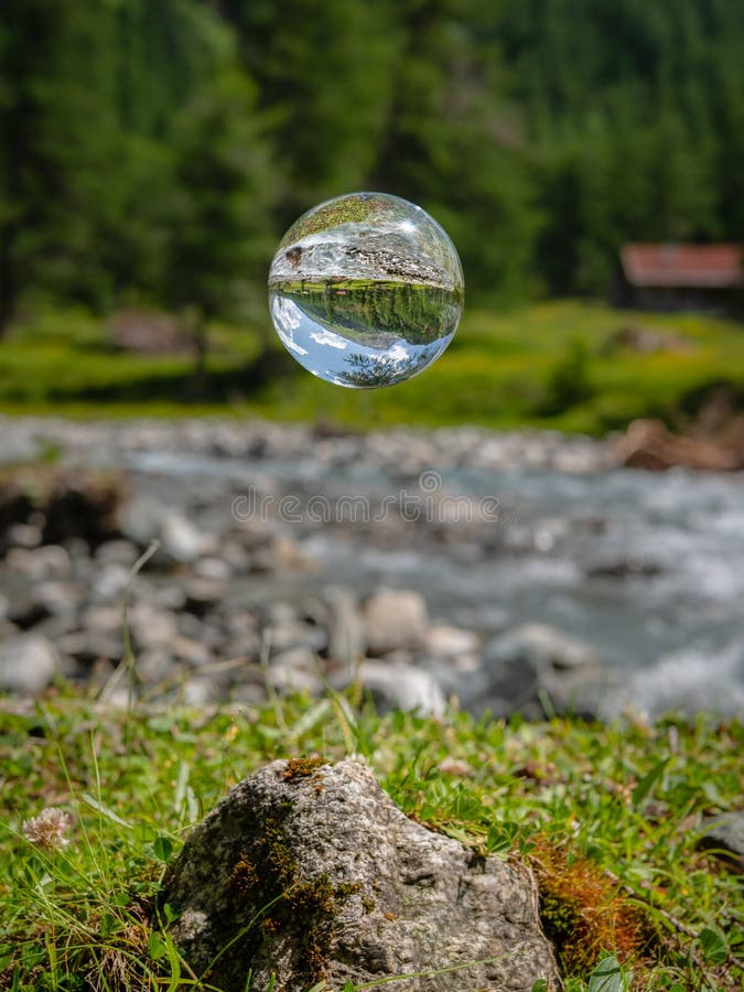 Glass sphere floating, river in Austrian alps, Dorfer Tal in National Park Hohe Tauern, sunny day in summer. Glass sphere floating, river in Austrian alps, Dorfer Tal in National Park Hohe Tauern, sunny day in summer