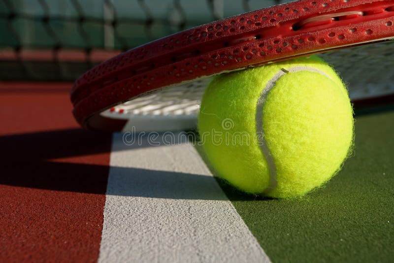 Sfera e racchetta di tennis su una corte immagini stock libere da diritti Sfera e racchetta di tennis su una corte immagini stock libere da diritti