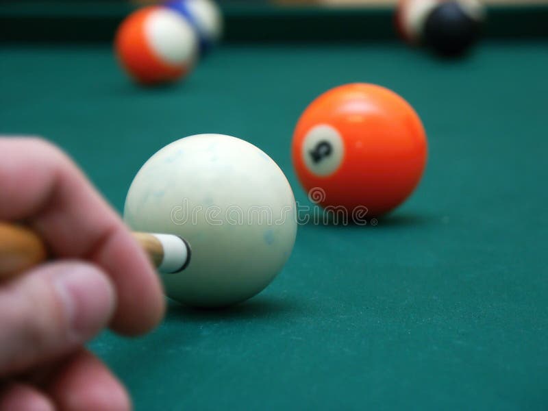 Billiard balls on green table with cue and hand. Billiard balls on green table with cue and hand