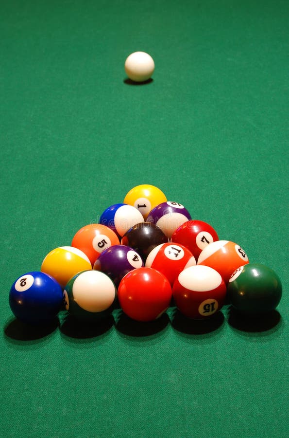 A pyramid of billiard balls racked up on a pool table. A pyramid of billiard balls racked up on a pool table.