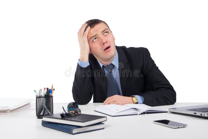 Sfrustowany młody biznesmen pracuje na laptopie przy biurem fotografia stock Sfrustowany młody biznesmen pracuje na laptopie przy biurem fotografia stock