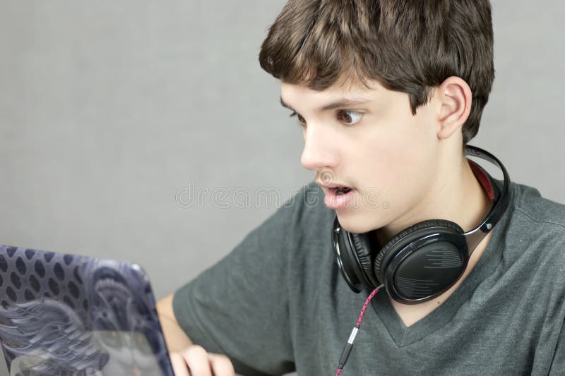 Sguardi teenager al calcolatore nella scossa fotografia stock libera da diritti Sguardi teenager al calcolatore nella scossa fotografia stock libera da diritti
