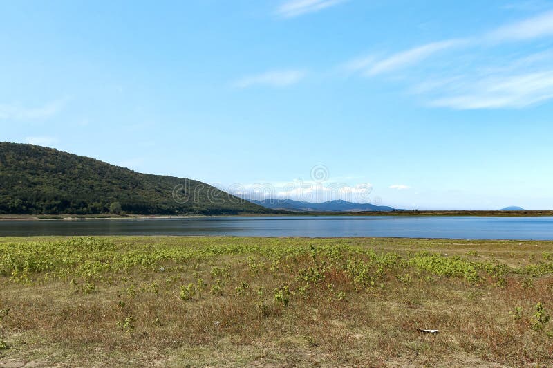 Sguardo di bellezza verso il lago pittoresco e la montagna Rabisha sopra la caverna di Magura immagine stock libera da diritti Sguardo di bellezza verso il lago pittoresco e la montagna Rabisha sopra la caverna di Magura immagine stock libera da diritti