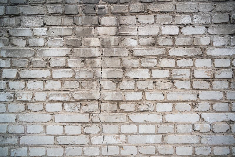 Shabby helle Ziegelwand mit Riss lizenzfreie stockfotografie