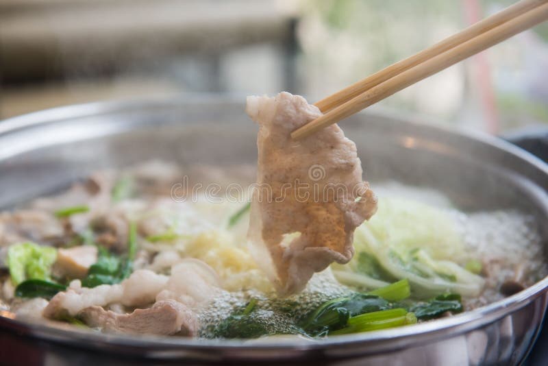 Shabu Shabu oder Sukiyaki oder heißer Topf, Hand, die Schweinefleisch unter Verwendung der Essstäbchen, japanisches Lebensmittel stockfoto Shabu Shabu oder Sukiyaki oder heißer Topf, Hand, die Schweinefleisch unter Verwendung der Essstäbchen, japanisches Lebensmittel stockfoto