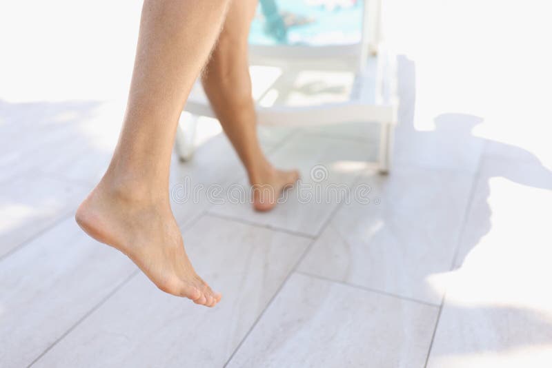 Close-up of persons feet step on tile near pool, barefoot man with hairy legs. Tanned body skin, enjoy summer vacation, hot days. Holiday, resort, summertime, chill concept. Close-up of persons feet step on tile near pool, barefoot man with hairy legs. Tanned body skin, enjoy summer vacation, hot days. Holiday, resort, summertime, chill concept